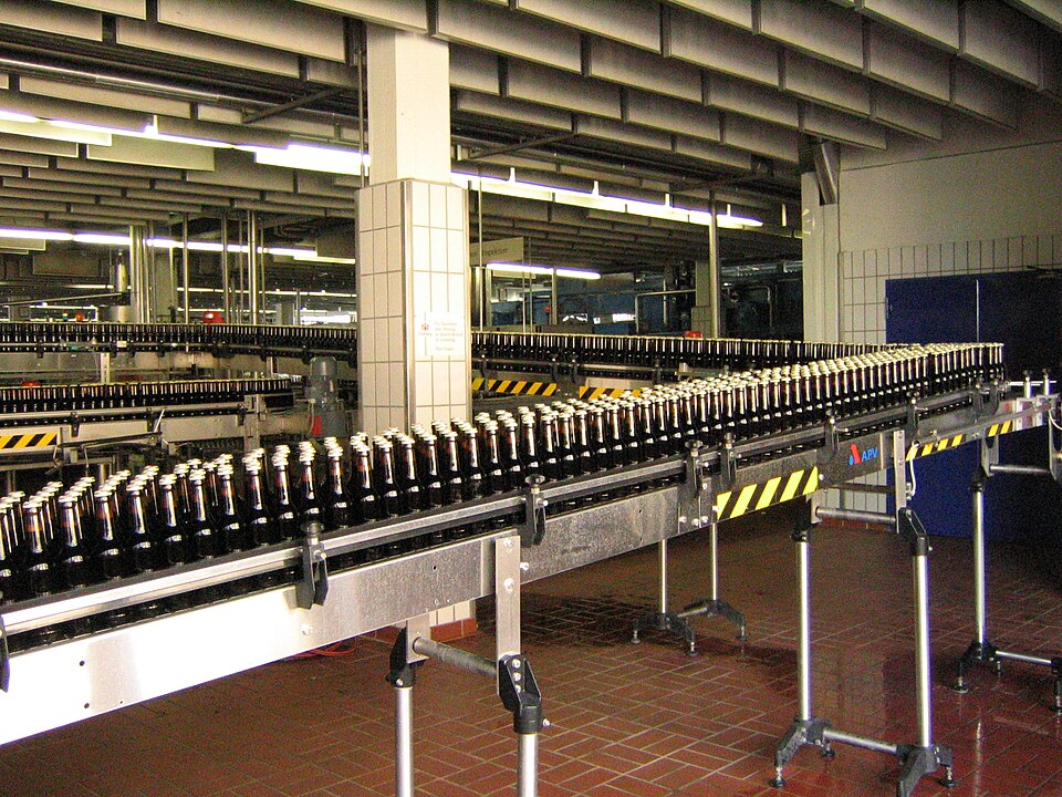 A conveyor belt carrying bottles Flominator, CC BY-SA 3.0, via Wikimedia Commons